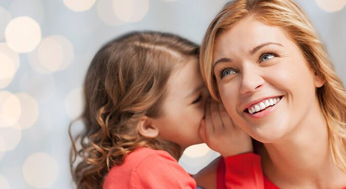 Niña le cuenta un secreto a su madre