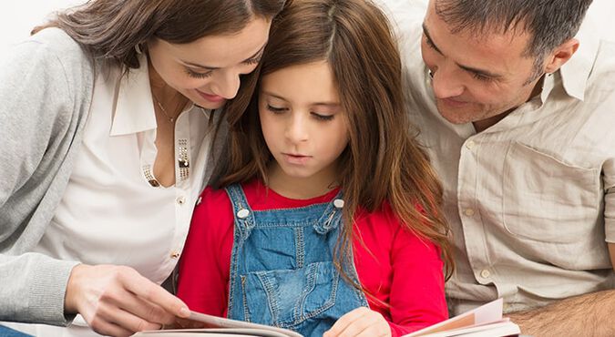 Padres leyendo un libro con su hija