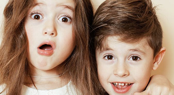 Dos hermanos abrazados con cara de sorprendidos