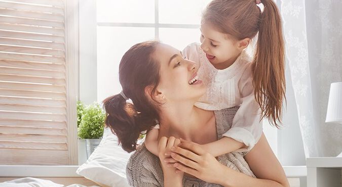 Niña subida en los hombros de su madre